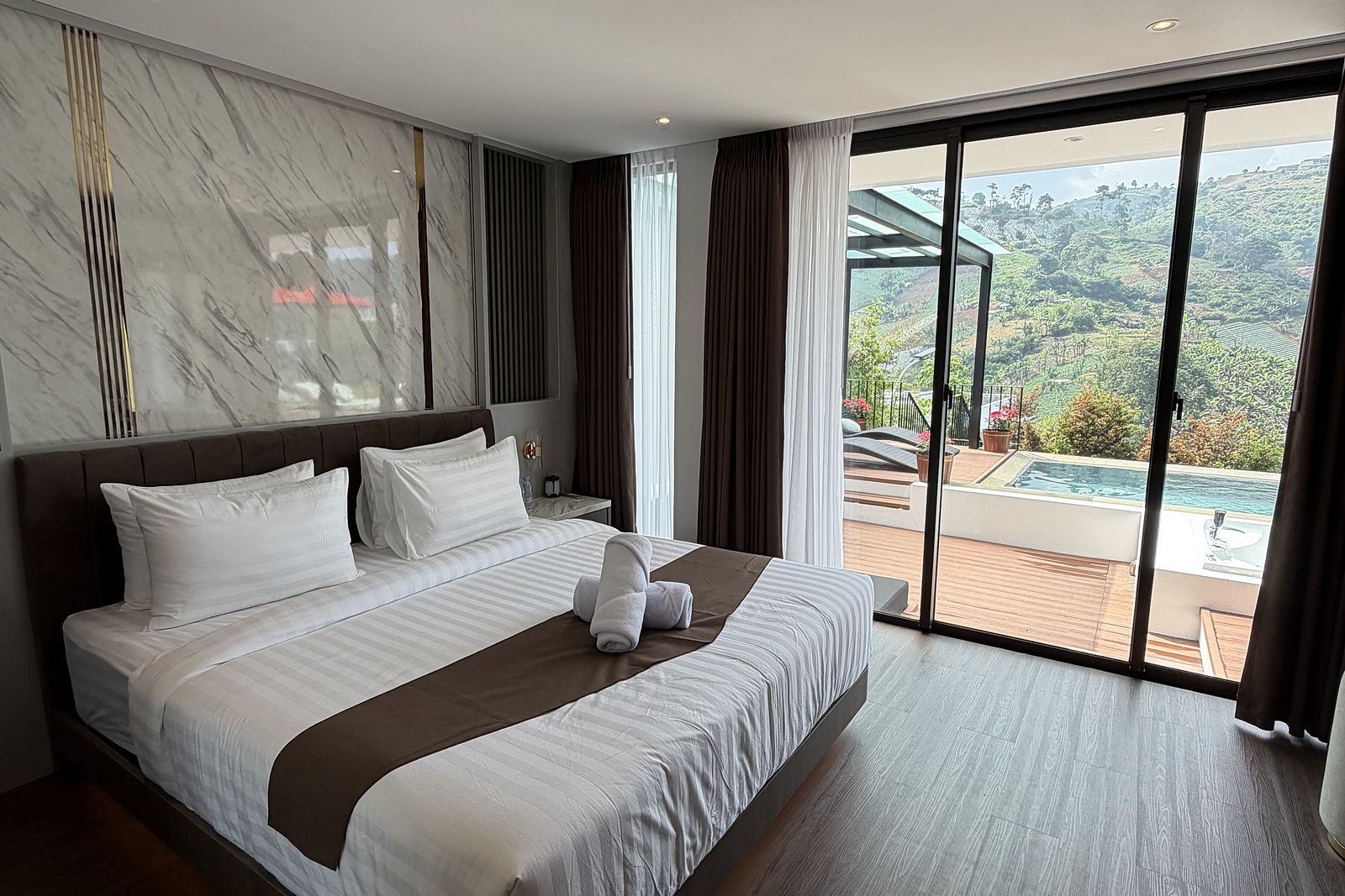 A bedroom with sliding doors onto the pool deck and the valley