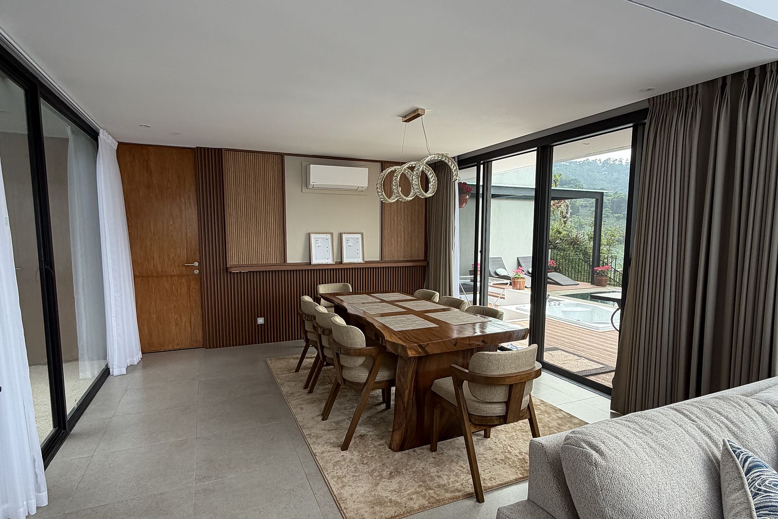 The open-plan living and dining space, opening onto the pool